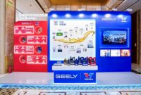 A display booth featuring Valvoline GEELY collaboration, showcasing co-developed lubricants and a timeline of their partnership, with product bottles arranged on a central table.